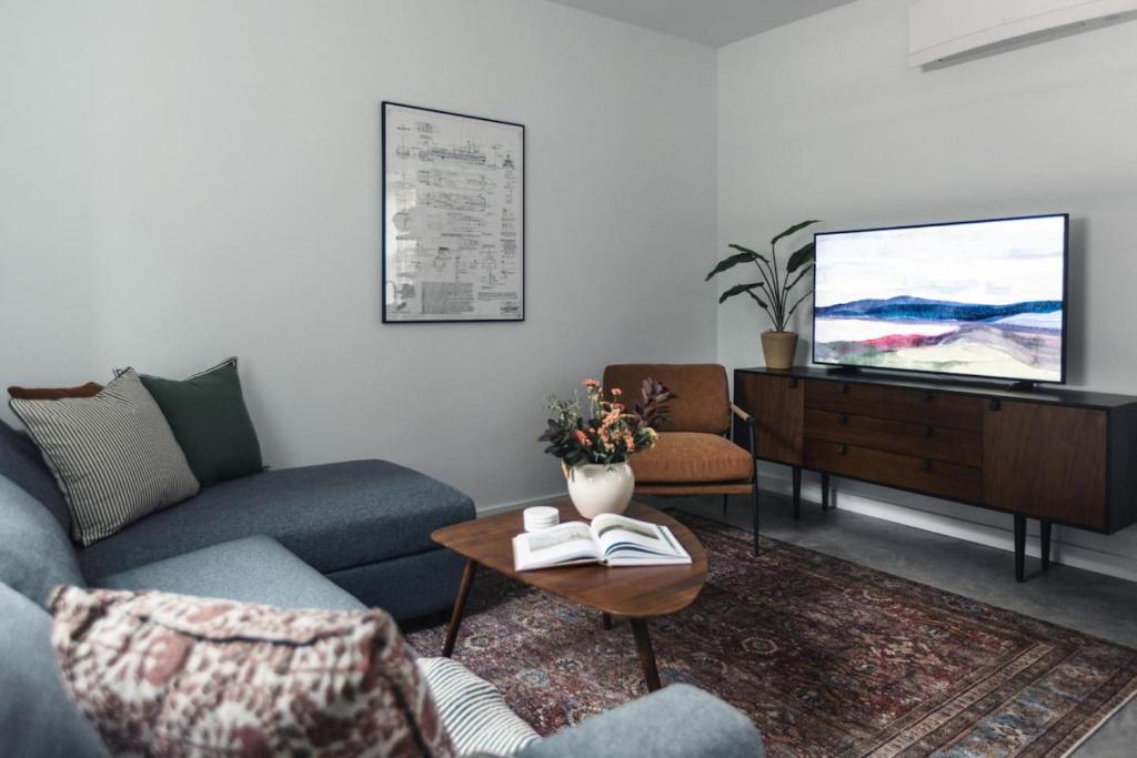 ein Wohnzimmer mit Sofa und Fernseher in der Unterkunft The Brickworks at the 1896 Building in Kaslo