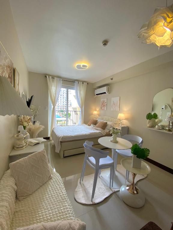 a living room with a bed and a couch and tables at Yahay-living & Condotel in Suba