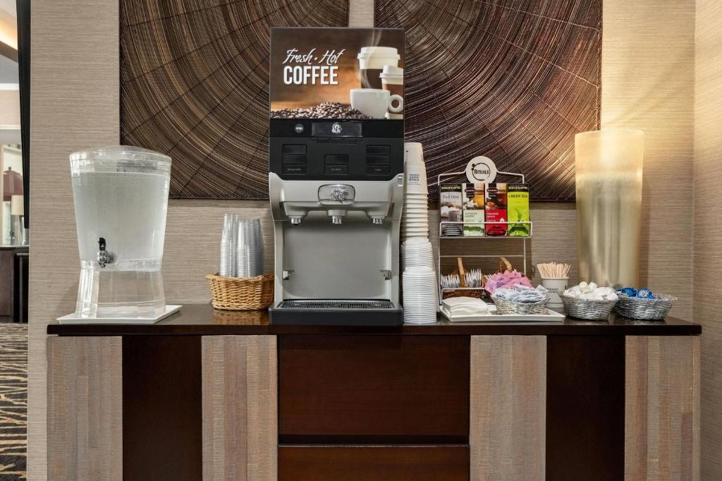 a coffee shop with a coffee machine on a table at Ramada by Wyndham Grand Forks in Grand Forks