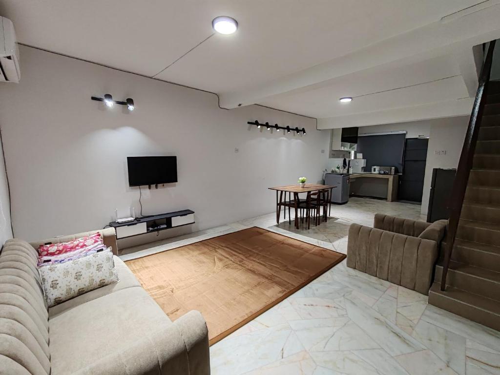 a living room with a couch and a table at Tambun - Near LWOT, PLUS Highway Access ,Sunway & Pantai Hosp in Tambun