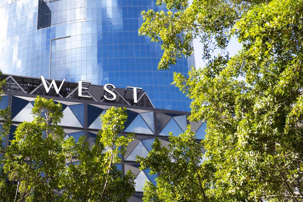 a glass building with the word west on it at West Hotel Sydney, Curio Collection by Hilton in Sydney