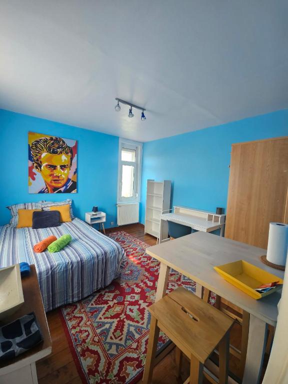 a bedroom with a bed and a blue wall at L'Irisée in Liévin