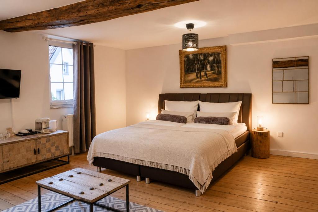 a bedroom with a large bed and a television at Boutique Hotel Marielle in Bad Münstereifel