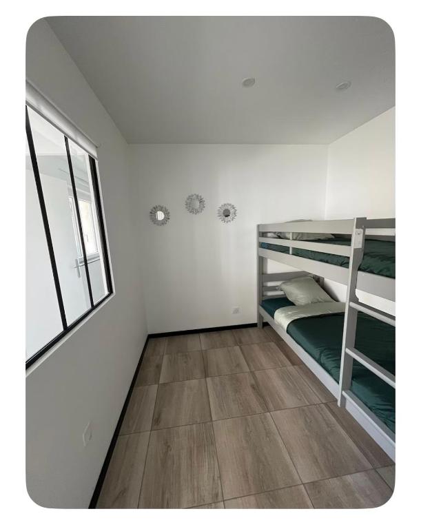 a bedroom with two bunk beds and a window at Chez Melanie in Neuilly-le-Réal