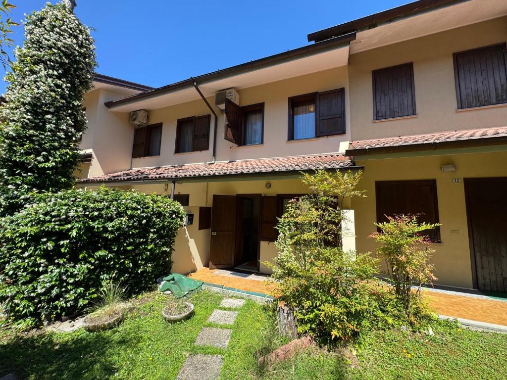 a large house with a yard in front of it at Villa Dosso Fiorito in Lignano Sabbiadoro