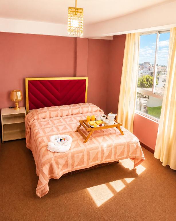 a bedroom with a bed with a tray of food on it at Hotel Golden La Paz in Callampaya