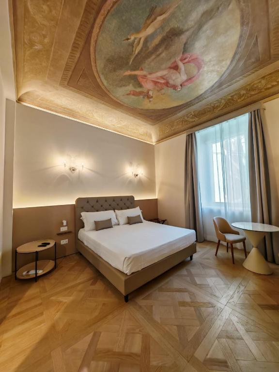 a bedroom with a large bed with a painting on the ceiling at Palazzo Cortesi Boutique Hotel in Macerata