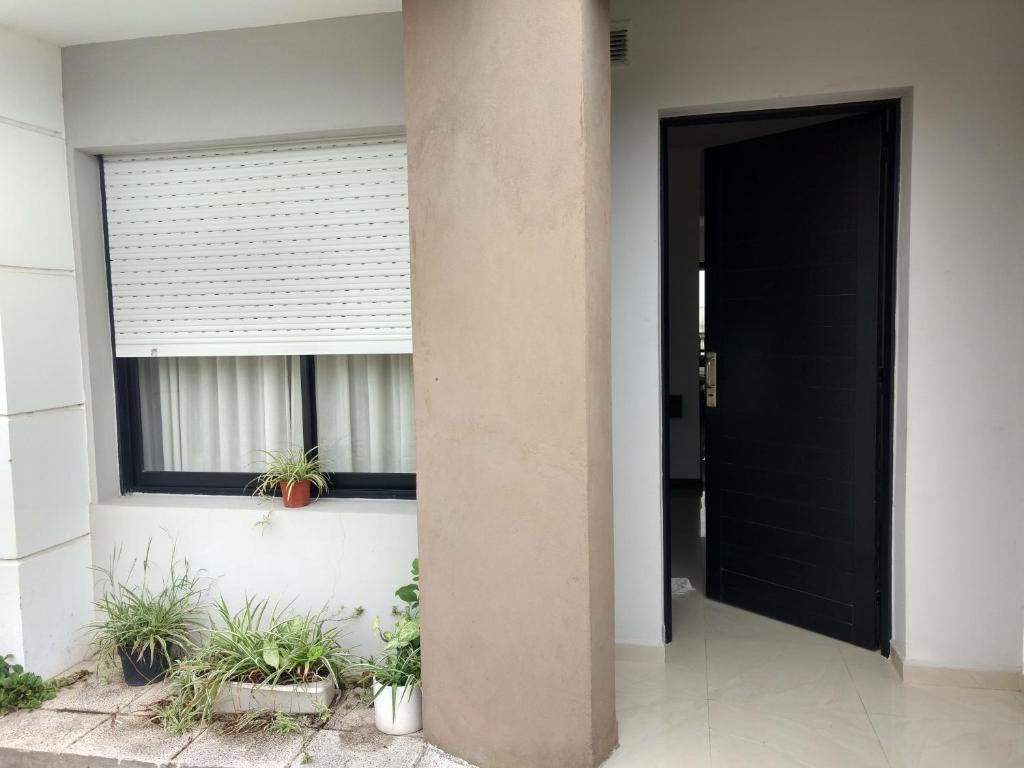 a black door in a building with potted plants at Mein Gästehaus in Gualeguaychú