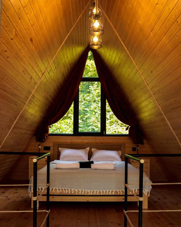 a bed in a room with a large window at Machakhela Peaks in Sindietʼi