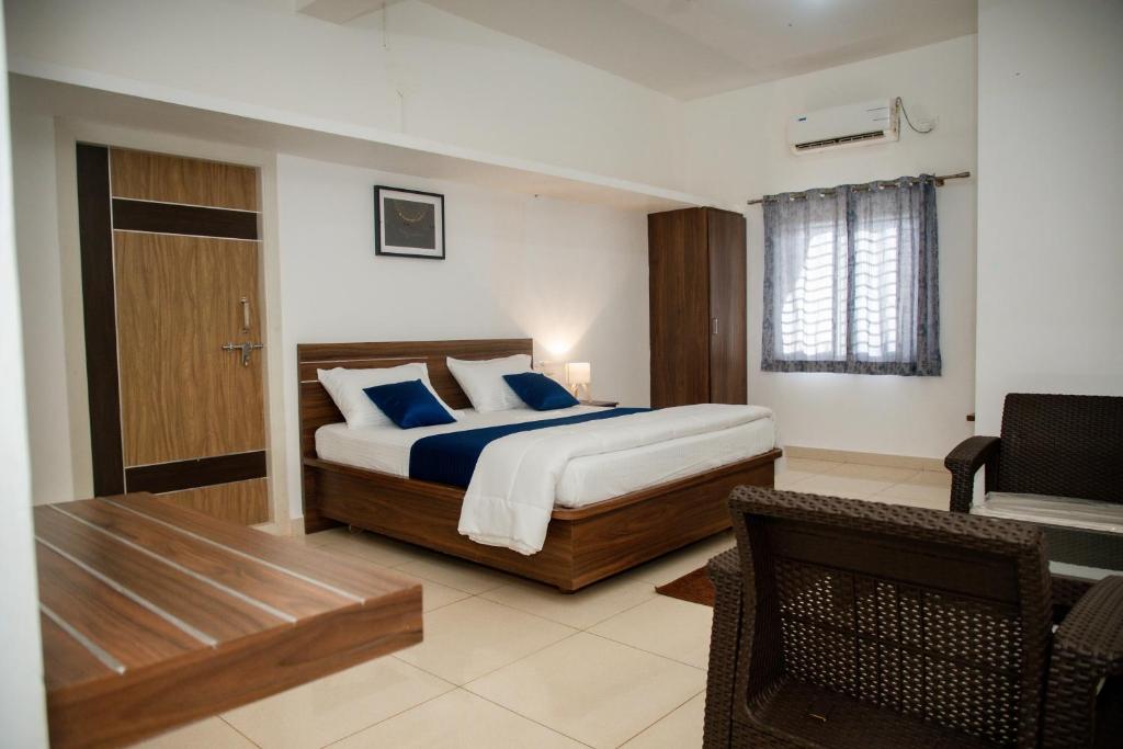 a bedroom with a king sized bed and a desk at Sushi Greens Suites in Dāvangere