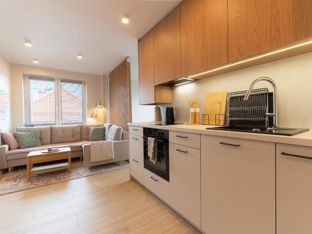 a kitchen and living room with a couch at Apartament Bohaterów in Giżycko