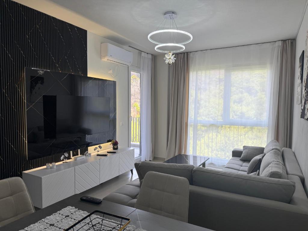 a living room with a couch and a tv at Shengjin Apartament 5 M in Shëngjin