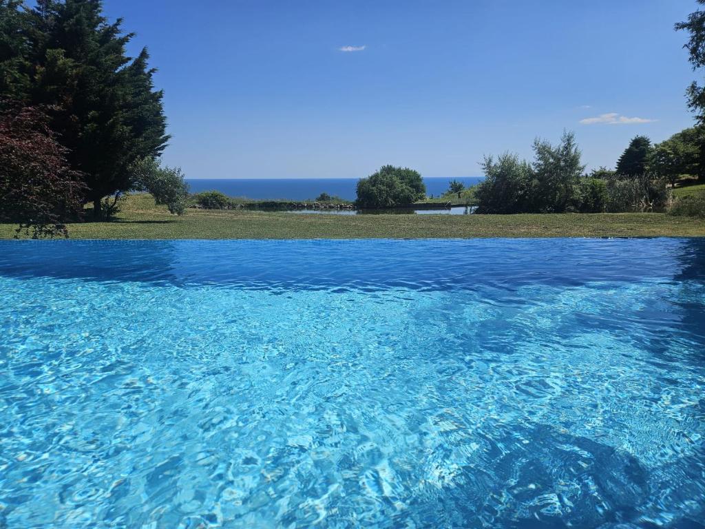 a pool of blue water with trees in the background at Luxury villas and golf GV6 in Balchik