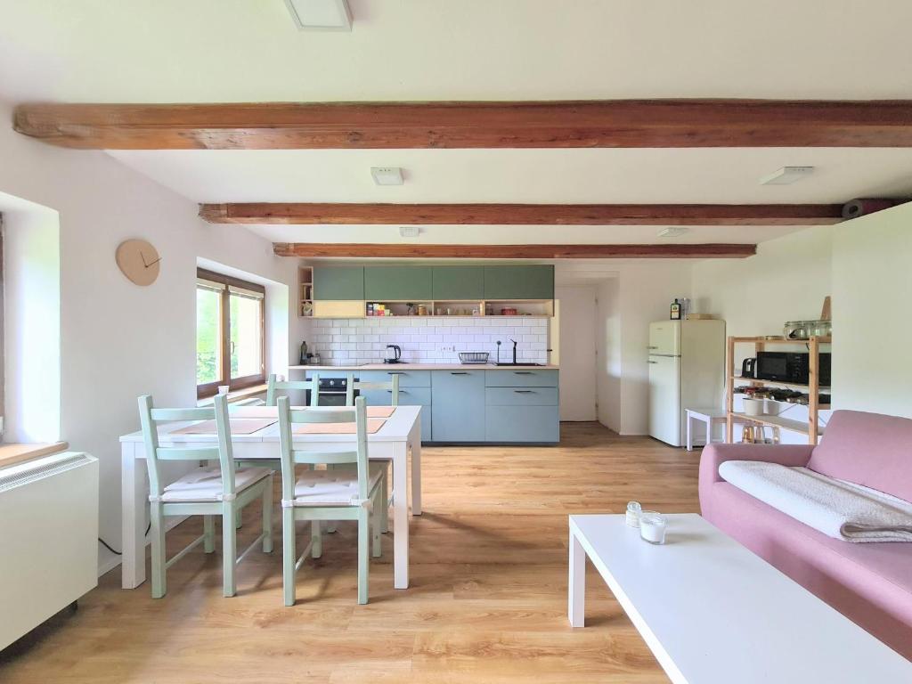a kitchen and living room with a table and chairs at Apartmán na Špičáku in Špičák