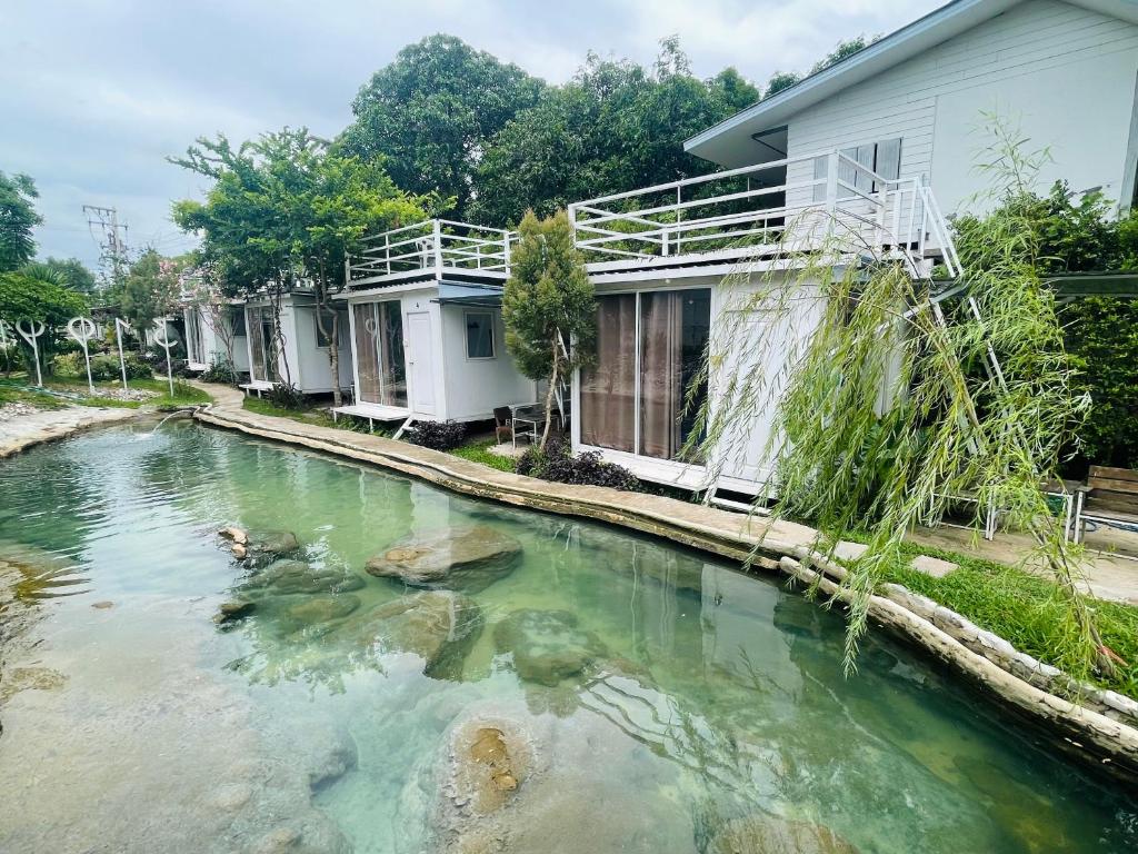 a pool of water in front of a house at 3199 Cafe' Latya & Bed in Ban Lum Makok