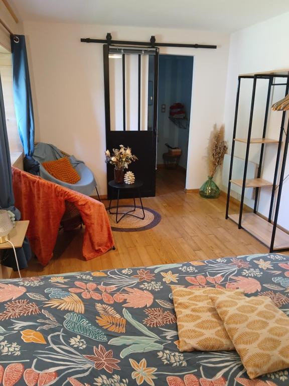 a living room with a bed and a room with a table at L étable au naturel in Mauriac