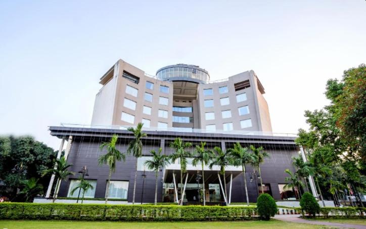 a large building with palm trees in front of it at Holiday Home Ranchi in Rānchī