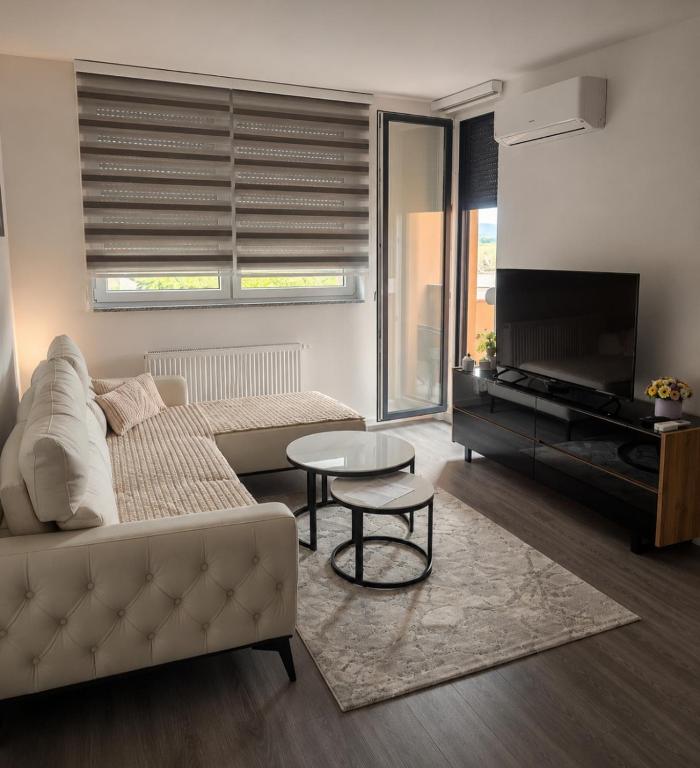 a living room with a couch and a table and a piano at Nora in Žepče