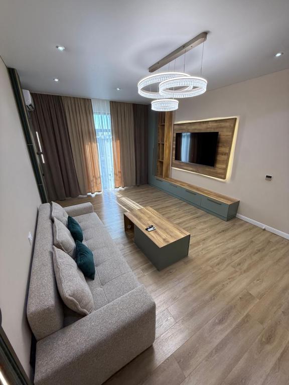 a living room with a couch and a flat screen tv at Tamerlane Premium Apartment in Samarkand