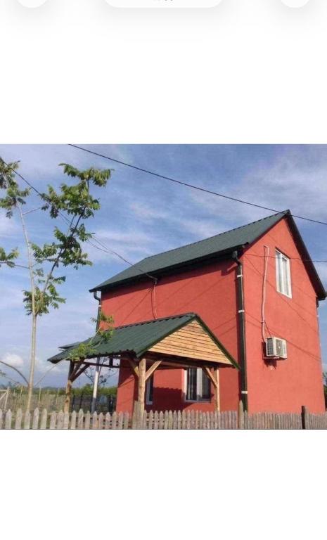 a red barn with a fence in front of it at Natali & Giga in Ureki