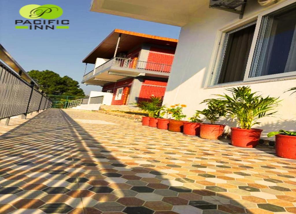 a building with a tiled sidewalk in front of a house at Pacific Inn Vistaar Hotels & Resorts in Chamba