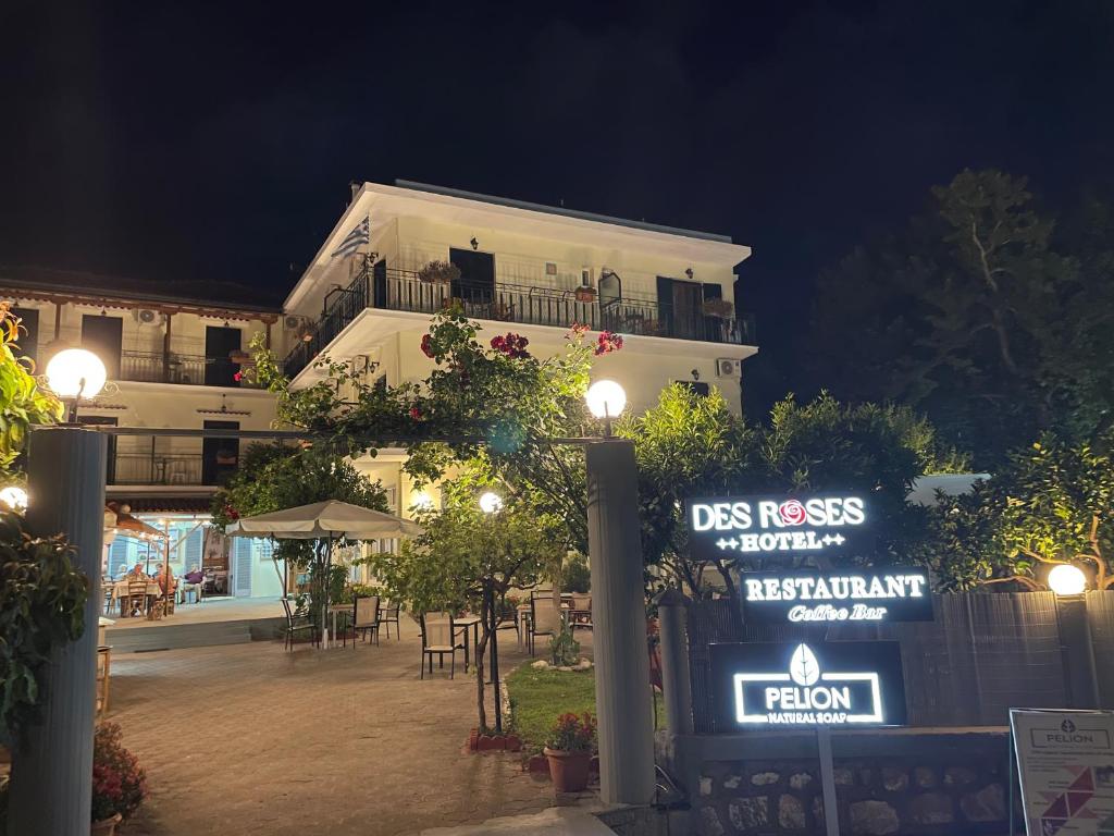a building with a sign in front of it at night at Des Roses Hotel in Platanias