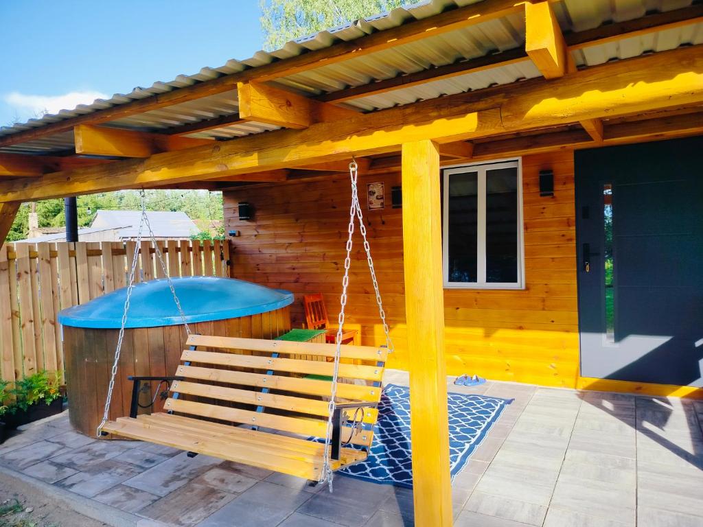 a swing in front of a wooden house at Chata z Pary in Giby