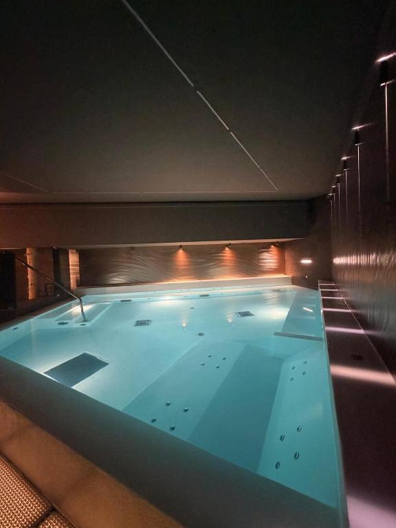 ein großes Schwimmbecken in einem Gebäude mit Beleuchtung in der Unterkunft Hotel Folgarida in Folgarida