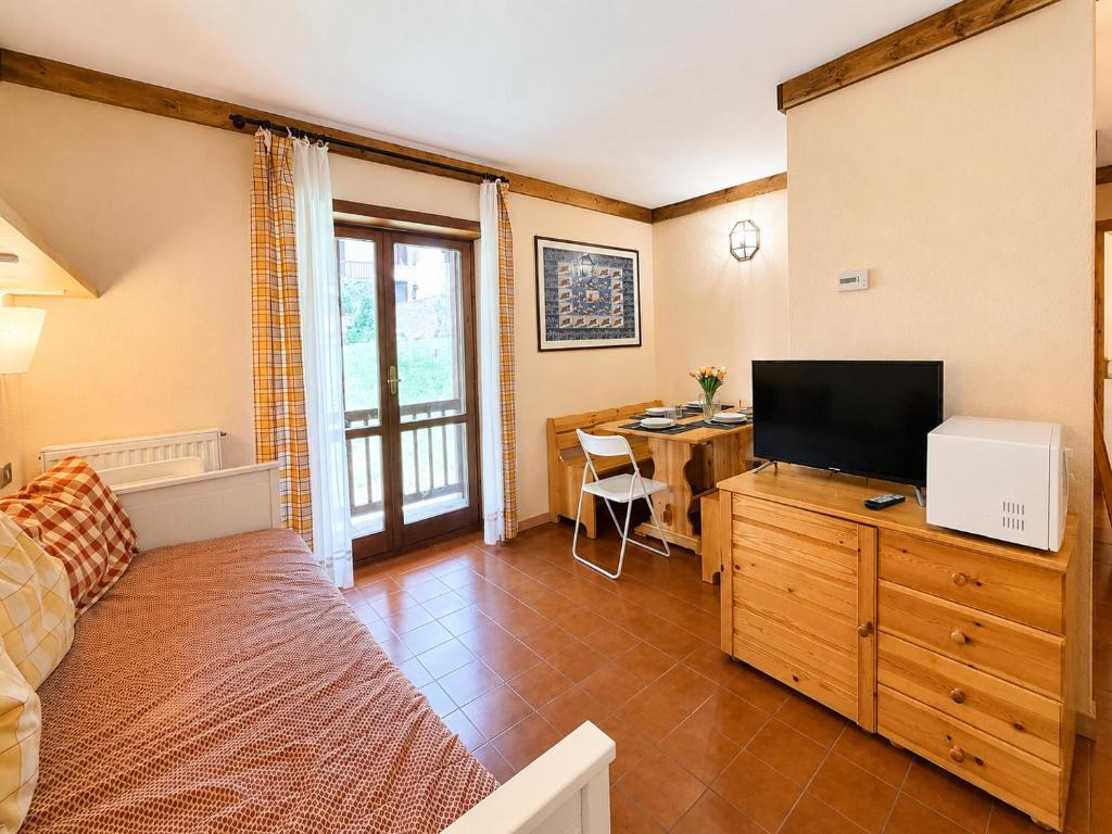 a bedroom with a bed and a desk with a television at Hostdomus - A3-24 in Grange Sises