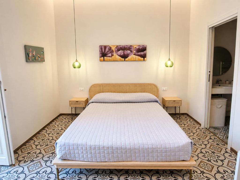 a bed in a room with two tables at Il Pumo in Locorotondo