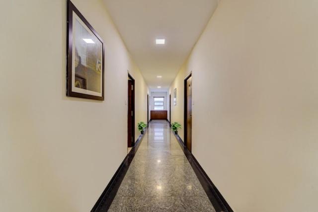 a hallway with white walls and a picture on the wall at RG Suites - Royapettah in Chennai