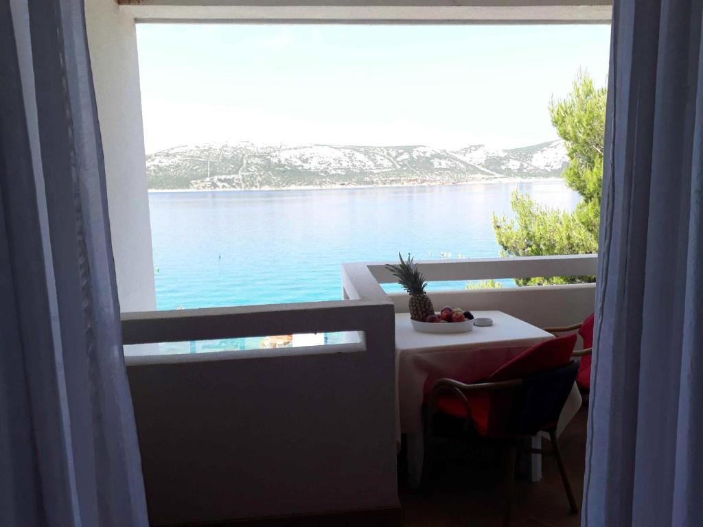 a window with a table and a view of the water at Arka in Stara Novalja
