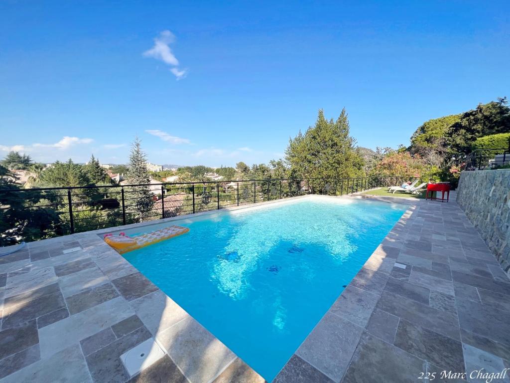 a swimming pool with blue water on a patio at Holiday home "225 Marc Chagall" in Mandelieu-La Napoule