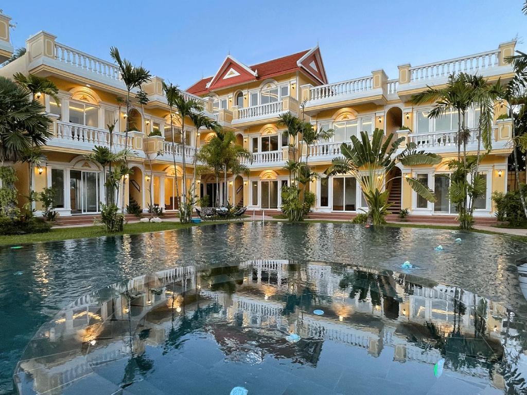 a large building with a pool in front of it at Sokchea Kampot Hotel in Kampot