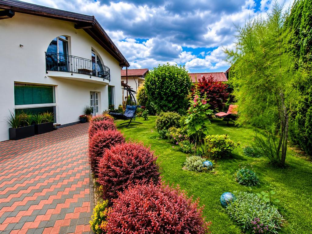 a garden with colorful plants in front of a house at Vila Bijou in Borşa