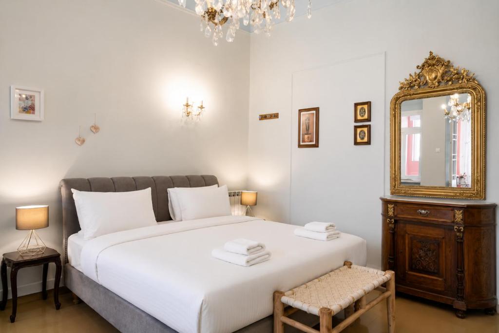 a bedroom with a large white bed and a mirror at Neoclassical Mansion in Andros Town by Explore Andros in Andros