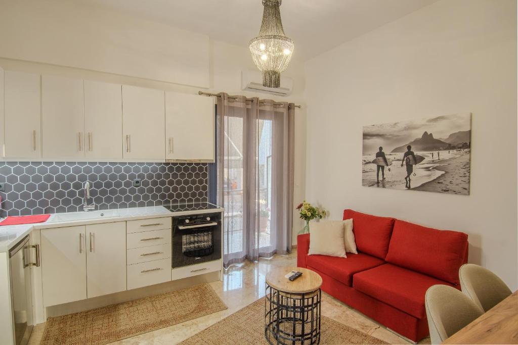 a living room with a red couch and a kitchen at Grimihome 2 in Filiatra