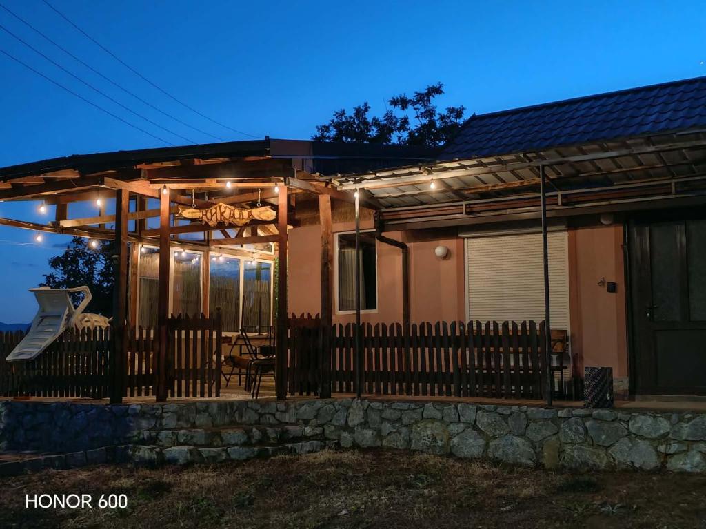 a house with a fence and lights on it at Trpejca Аpartment Nikola in Trpejca