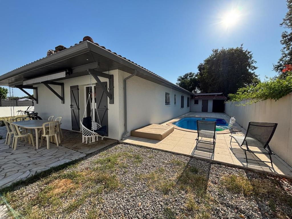 a patio with a table and chairs next to a house at Maison au calme avec piscine et jardin in BOD
