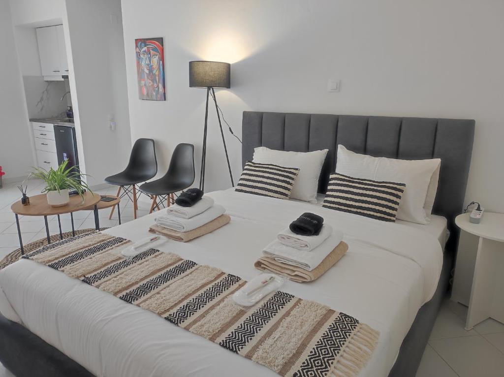 a bedroom with a large white bed with two chairs at Studio Scirocco in Tympáki