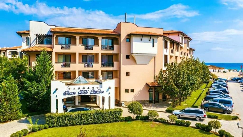 a hotel with cars parked in a parking lot at Hotel Oasis Del Mare in Lozenets