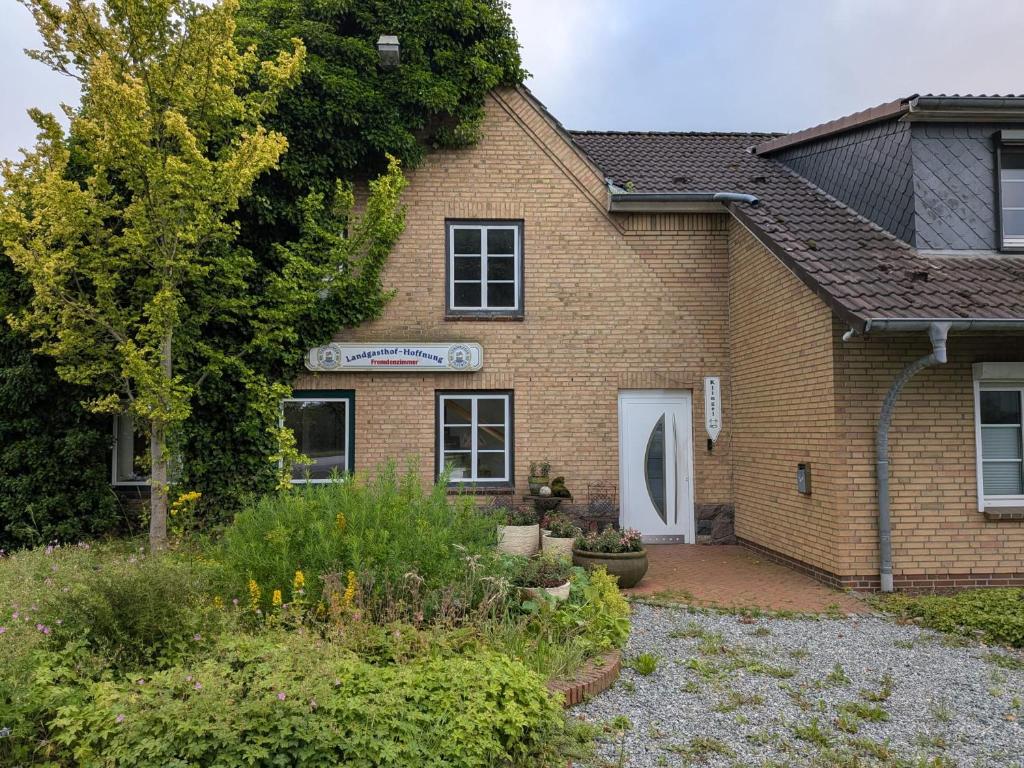 a brick house with a garden in front of it at Hansens Zimmervermietung in Handewitt
