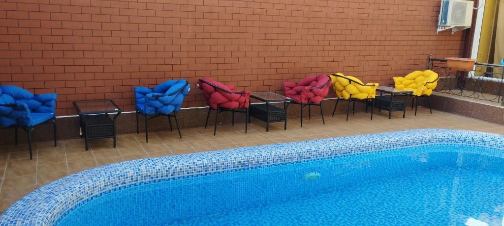 a group of chairs sitting next to a swimming pool at Green house eco hotel Samarkand in Samarkand