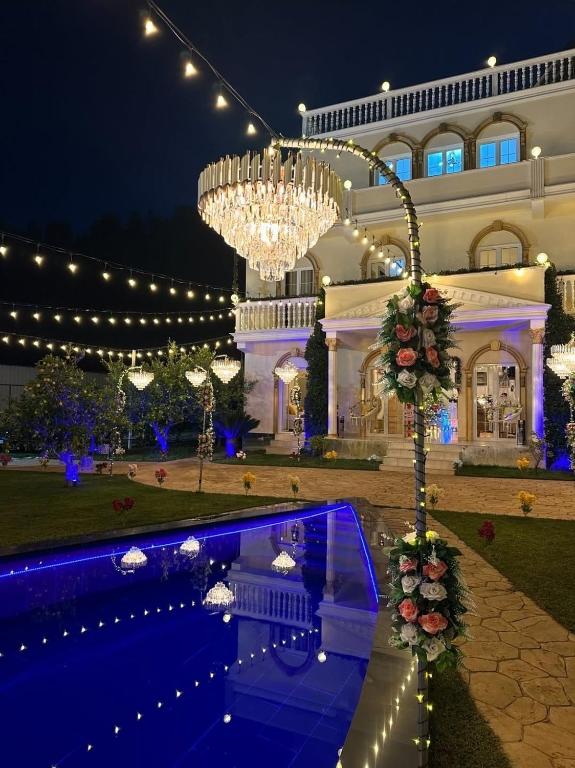 a large building with a chandelier and a pool at Vila Dy Bukurite Durres in Draç