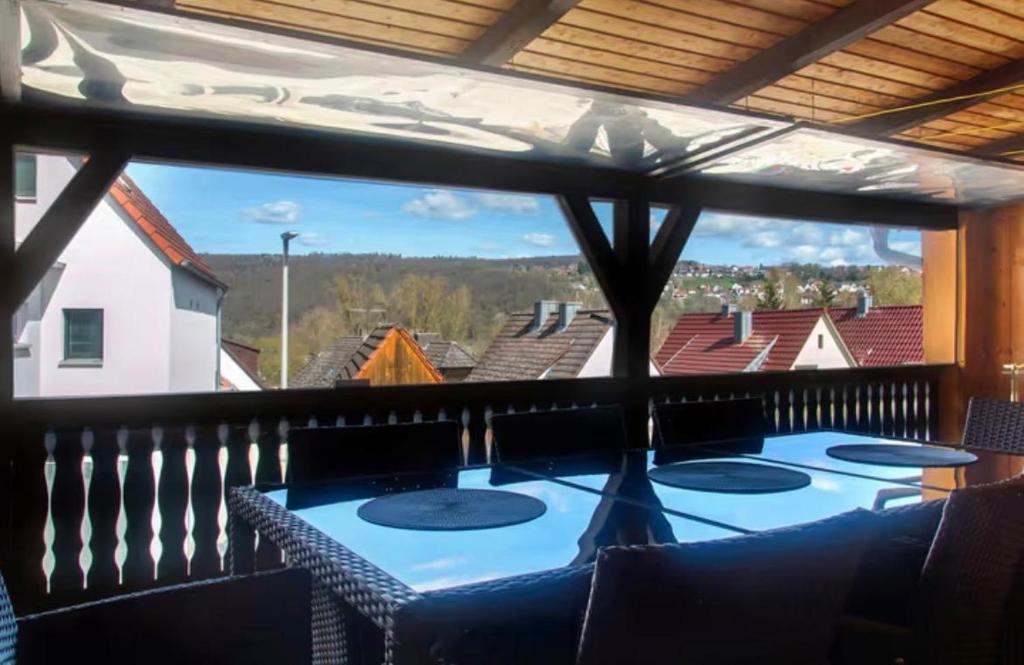 a balcony with a table and chairs and a large window at Gemütliche Wohnung am Main 1 in Gemünden