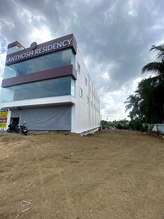 a building with a sign on the side of it at SANTHOSH RESIDENCy in Chengalpattu