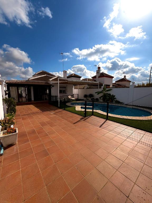 a backyard with a fence and a swimming pool at Chalet Matalascañas in Matalascañas