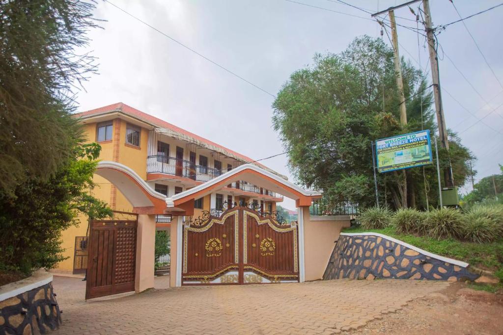 ein Haus mit einem Holztor davor in der Unterkunft FortBreeze Hotel in Fort Portal