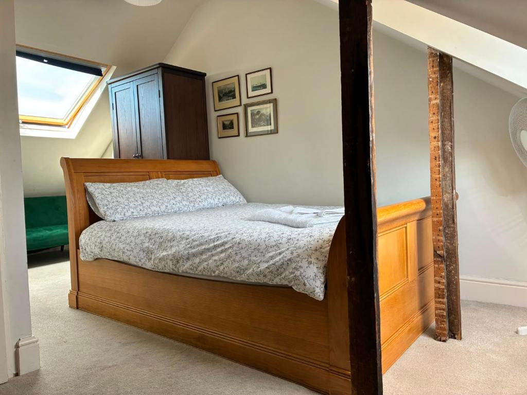 a bedroom with a wooden bed and a wooden dresser at Castle Room in Windsor