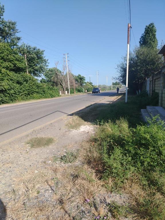 an empty road with a car driving down the road at Istisu in Müqtǝdir